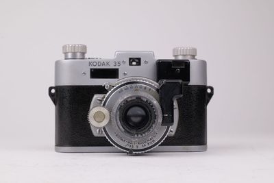 une photo en noir et blanc d'un appareil photo sur une surface blanche