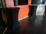 three tables with black cloths on them in a room