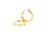 une paire de boucles d'oreilles en or sur fond blanc