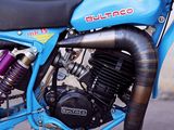 a blue dirt bike parked on the side of the road