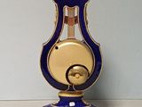 a blue and gold clock with a key on a table