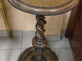 a small table with a glass top on a tile floor