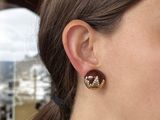 a close up of a woman wearing a pair of earrings