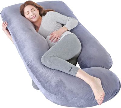 une femme enceinte allongée sur un grand oreiller gonflable pour le corps, sur un fond blanc
