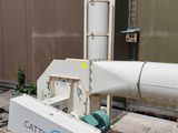 a machine that is sitting on the ground next to a pile of wood