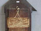 a wooden clock hanging on the wall with a bird on it