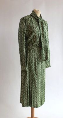 une photo d'une robe verte sur un présentoir à mannequin