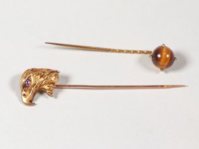 une paire d'épingles à cheveux dorées ornées d'une tête de tigre et d'une tête de tigre