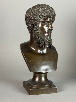 bronze bust of a man with curly hair and a beard