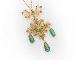 a gold and emerald necklace with a dangling pendant
