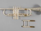 an old silver trumpet with a brass bell and two keys