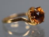 an image of a ring with a brown stone on top of a table