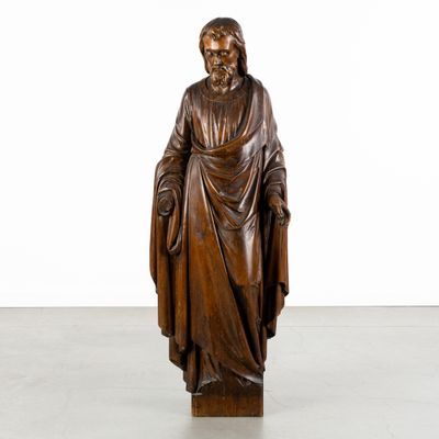 a wooden statue of a man with a robe on his head