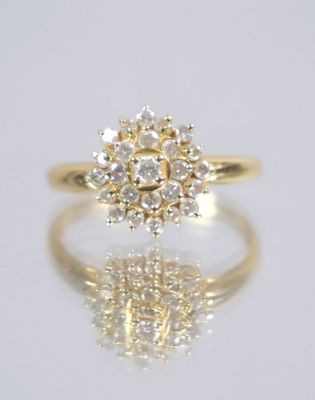 a close up of a diamond ring on a reflective surface
