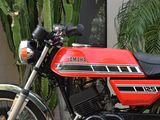 a red motorcycle parked in front of a cactus plant