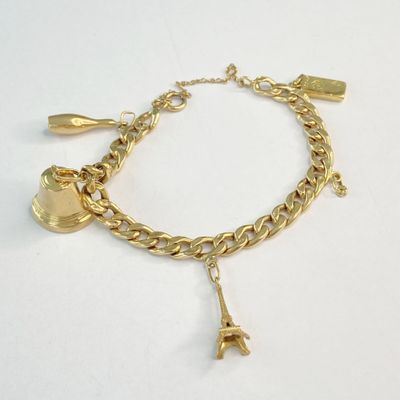 bracelet plaqué or avec des breloques et une croix sur une chaîne