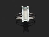 une bague sertie d'une aigue-marine et de diamants sur un fond noir