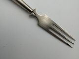 a close up of a fork on a white surface with a black handle