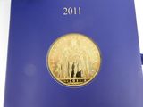 a blue book with a gold coin on top of it