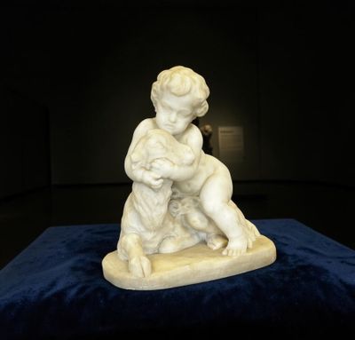 statue d'un garçon sur une planche de surf, posée sur un fond bleu