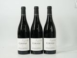 three bottles of wine are lined up on a white surface