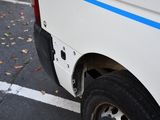 a white van with a blue stripe parked in a parking lot
