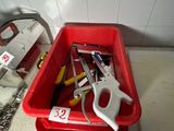 un bac rouge contenant des outils, posé sur un plan de travail