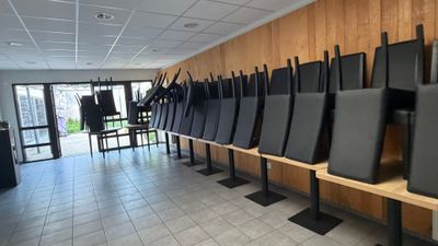 des rangées de chaises noires alignées les unes à côté des autres dans une pièce