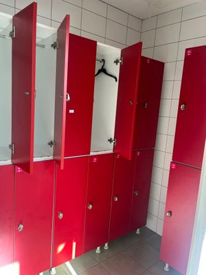 a row of red lockers in a public bathroom