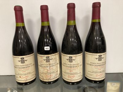 trois bouteilles de vin posées sur une table en verre, à côté d'une bouteille de vin