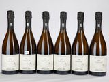 six bouteilles de vin sont alignées sur une table