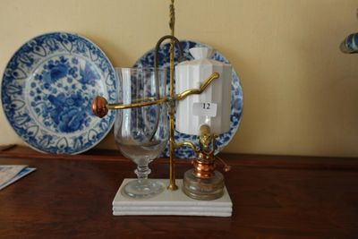 a blue and white plate on a table with a wine glass on it