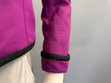 the back of a woman ' s purple jacket with black trims