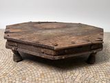 a small wooden table with a stone top on a tile floor