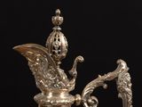 an antique silver plated coffee pot with a bird on it