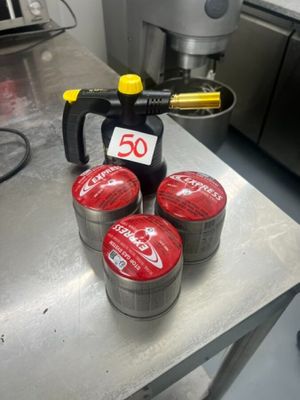 four cans of soda sitting on a table in a kitchen