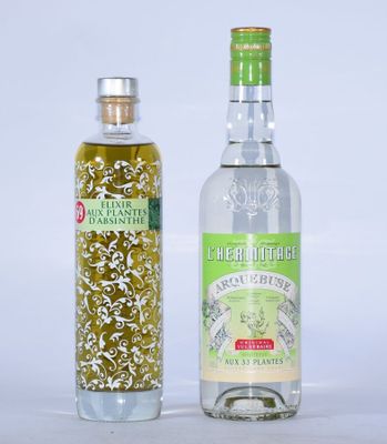 deux bouteilles d'huile d'olive et une bouteille d'huile d'olive posées sur une surface blanche