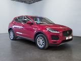 the red jaguar suv is parked in a showroom with a black floor