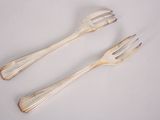 two forks and two spoons on a white surface