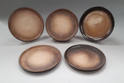 four brown plates sitting next to each other on a white surface