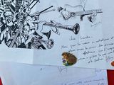 plusieurs dessins et lettres sont tracés au crayon sur un fond rouge
