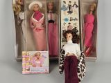 Trois poupées Barbie sont dans une boîte et l'une d'elles est assise sur une chaise.