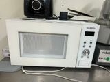 a microwave sitting on top of a counter next to a blender and a blender