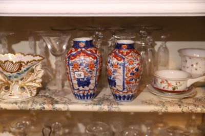 de nombreux vases et tasses sur une étagère dans la cuisine