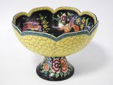 a yellow and black bowl with birds and flowers on it