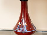 une lampe posée sur une table, avec un abat-jour rouge