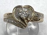 a heart shaped diamond ring on a clear glass stand