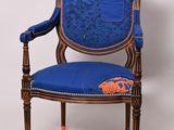 une image représentant une chaise bleue avec un coussin bleu et une bordure orange