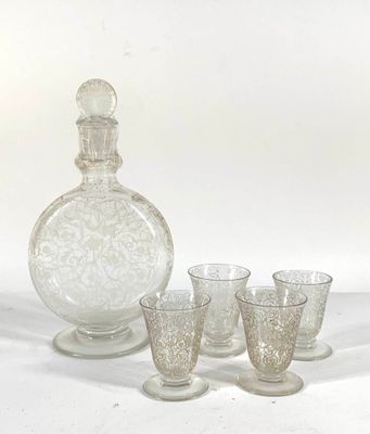 four glasses and a decanter sitting on a table