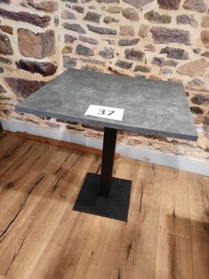 a small table with a number on it in front of a stone wall